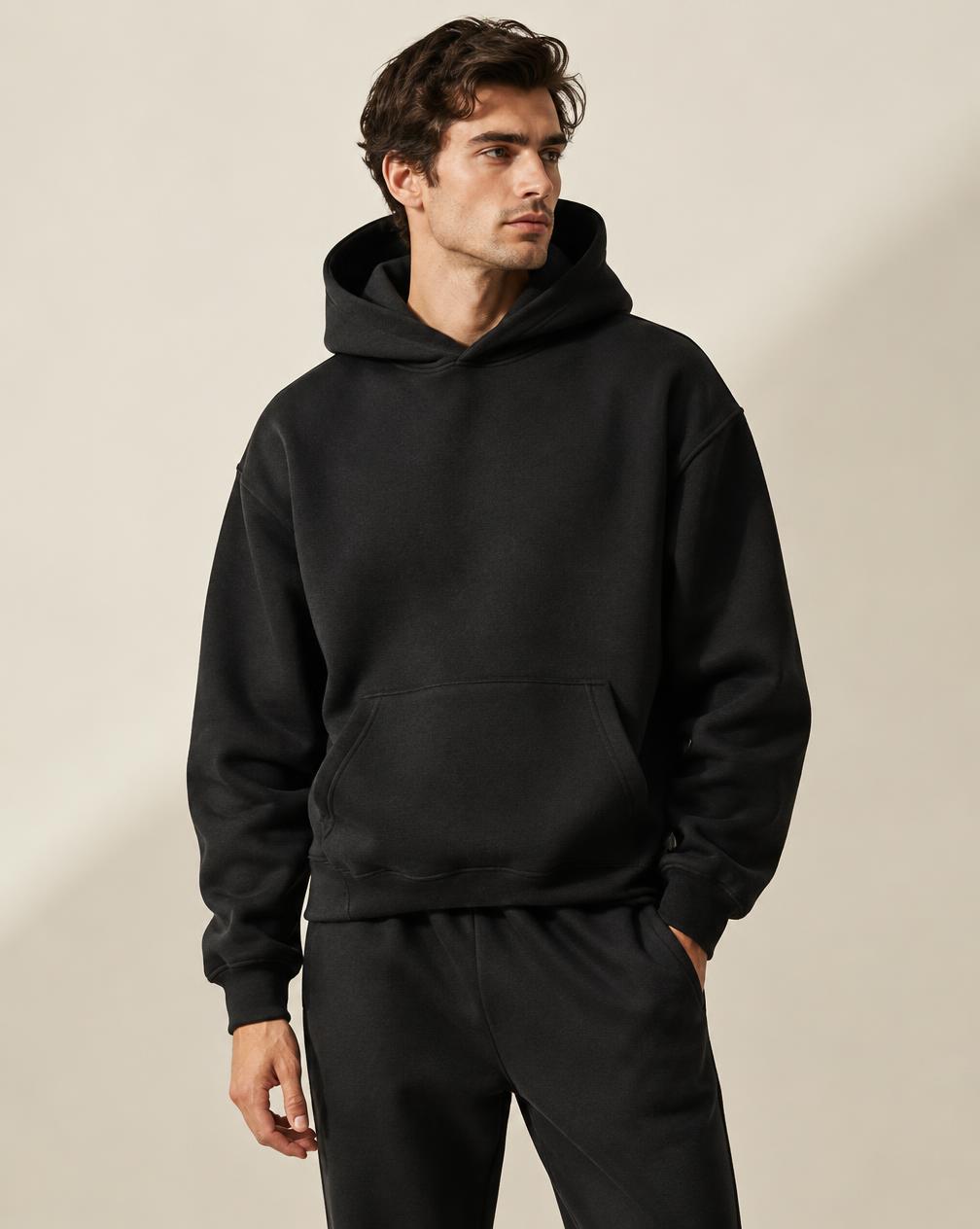 Hoodie noir minimaliste porté en ensemble monochrome